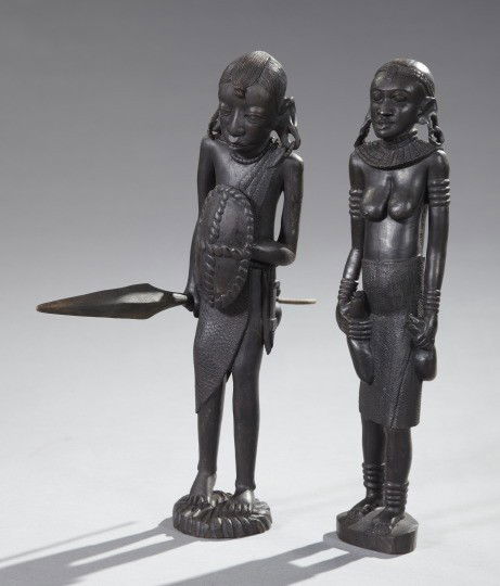 Two African Carved Ebony Figures,: Two African Carved Ebony Figures, 20th century, comprised of a female figure holding two vessels and a male figure holding a shield and spear, h. 17".