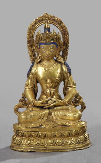 Nepalese Gilt-Bronze Figure of the Seated Buddha: Nepalese Gilt-Bronze Figure of the Seated Crowned Buddha, second quarter 19th century, the figure depicted in the lotus position, with matte royal blue enamel details, h. 7", w. 4-1/4", d. 3-1/4".