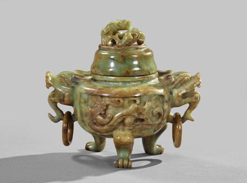 Kuang Hsu Carved Jade Ceremonial Vessel: Kuang Hsu Carved Green and Russet Jade Covered Ceremonial Vessel, first quarter 20th century, of ringed dragon-handled and paw-footed form in the Ming Dynasty style, the high-domed cover surmounted by