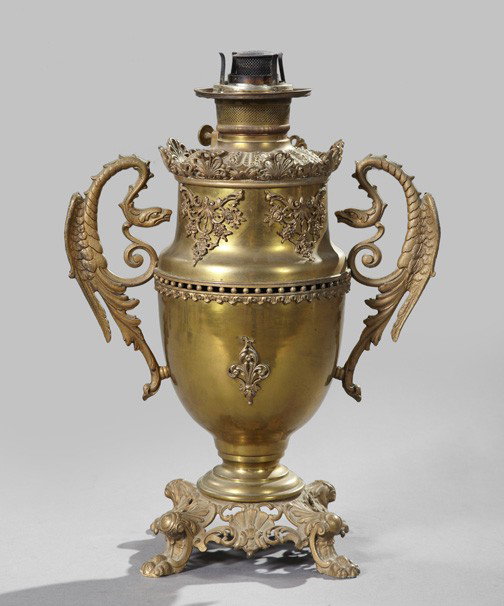 American Vasiform Kerosene Parlor Lamp: American Brass and Cast-Iron Vasiform Kerosene Parlor Lamp, fourth quarter 19th century, in the Beaux Arts taste, fitted with dragon handles, the gilded cast-iron base with four boldly modeled paw fee