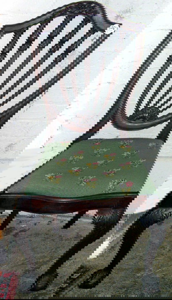 CHIPPENDALE SIDE CHAIR: Carved Mahogany Shield-Back Sidechair, in the manner of Thomas Chippendale, first quarter 20th century, the arched crestrail centered by relief ribbon carving, the serpentine seat raised on acanthus-c