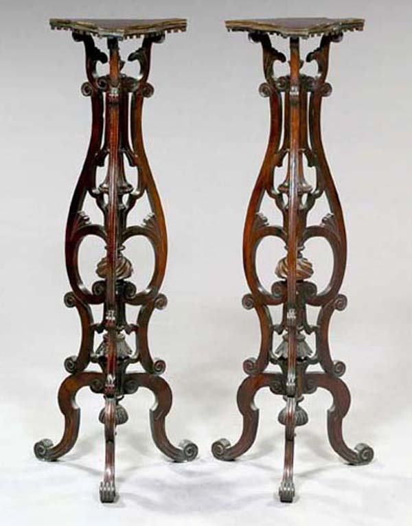 VICTORIAN PEDESTALS: Pair of English Tripodal Carved Mahogany Torchères, in the rococo style of Thomas Chippendale, third quarter 19th century,the tops of cartouche form with pendant dentillated edges, the whole supporte