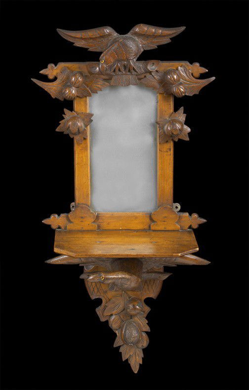 Lindenwood and Walnut Console Shelf: South German Provincial Carved Lindenwood and Walnut Console Shelf with Integral Looking Glass, third quarter 19th century, in the Schwartzwald style, the shelf supported on the wings of a displayed e