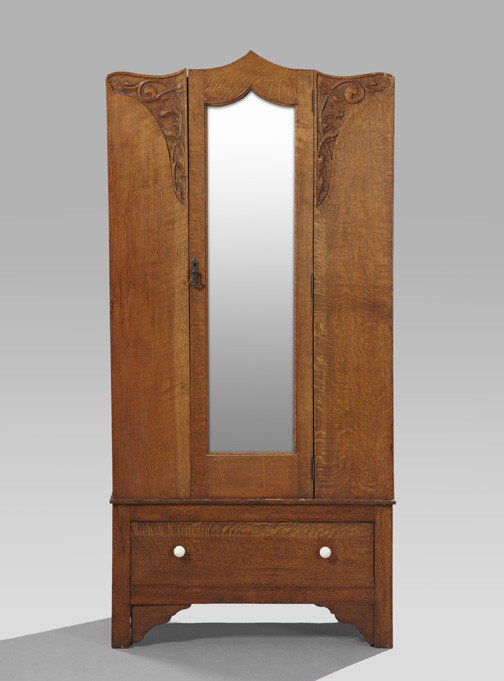 English Art Nouveau Oak Wardrobe,: English Art Nouveau Oak Wardrobe, first quarter 20th century, the carved crest over a conforming case fitted with a central mirrored door flanked by acanthine-carved panels, above a long drawer, raise
