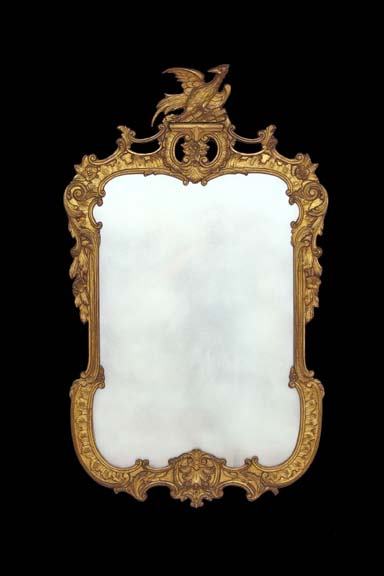 English Carved Giltwood Mirror: English Carved Giltwood Looking Glass, in the 18th-century rococo style of Thomas Johnson, the prominent cresting modeled as a phoenix perched on an openwork cartouche formed of a pair of addorsed, ru