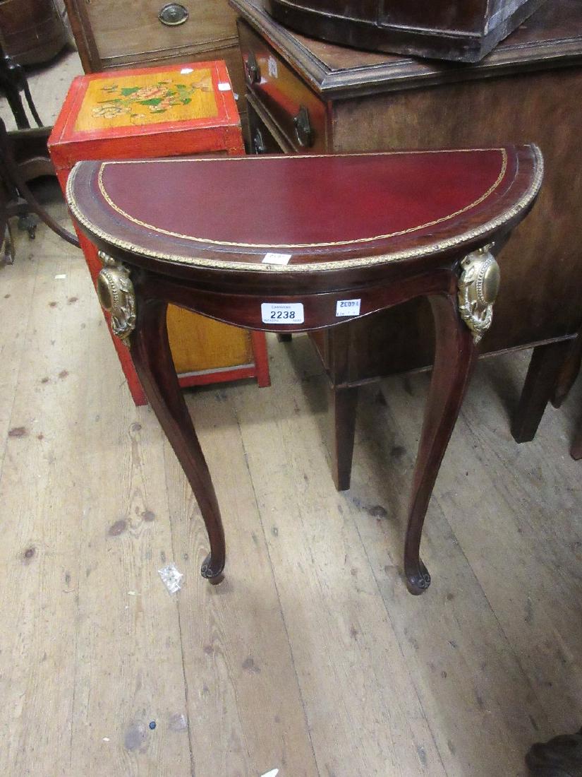 Pair of stained beechwood half round console tables: Pair of stained beechwood half round console tables with leather inset tops and gilt brass mounts