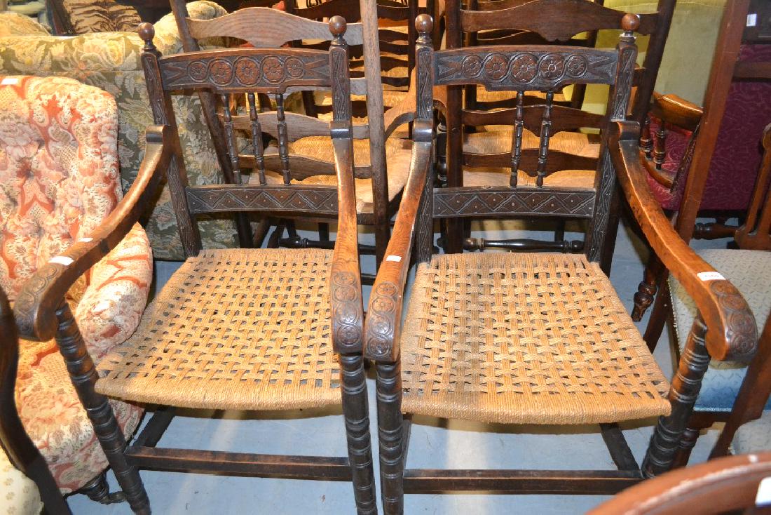 Pair of 19th Century French oak open elbow chairs with: Pair of 19th Century French oak open elbow chairs with rush seats (at fault)