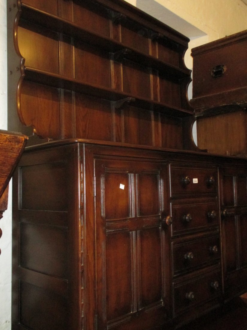 Ercol dark ash dresser having shelved back above four: Ercol dark ash dresser having shelved back above four central drawers and two panel doors on stile end supports