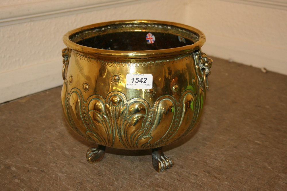 19th Century circular jardiniere stand with embossed: 19th Century circular jardiniere stand with embossed and repousse decoration, having lions head ring handles on low paw supports, 9ins high