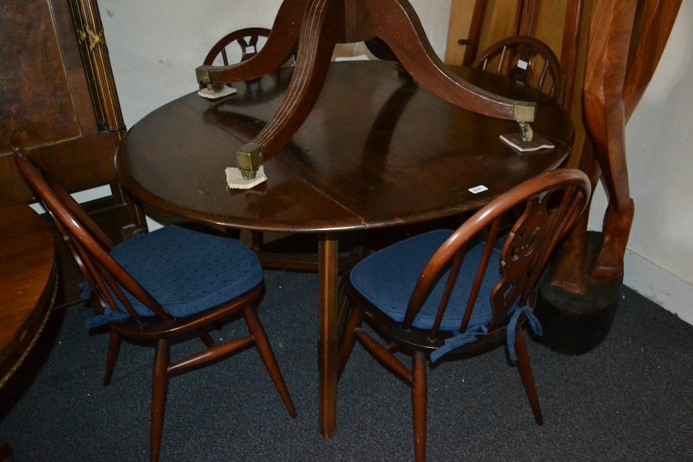1960's Ercol dark ash drop-leaf dining room table: 1960's Ercol dark ash drop-leaf dining room table together with a set of four matching wheelback chairs with loose cushions