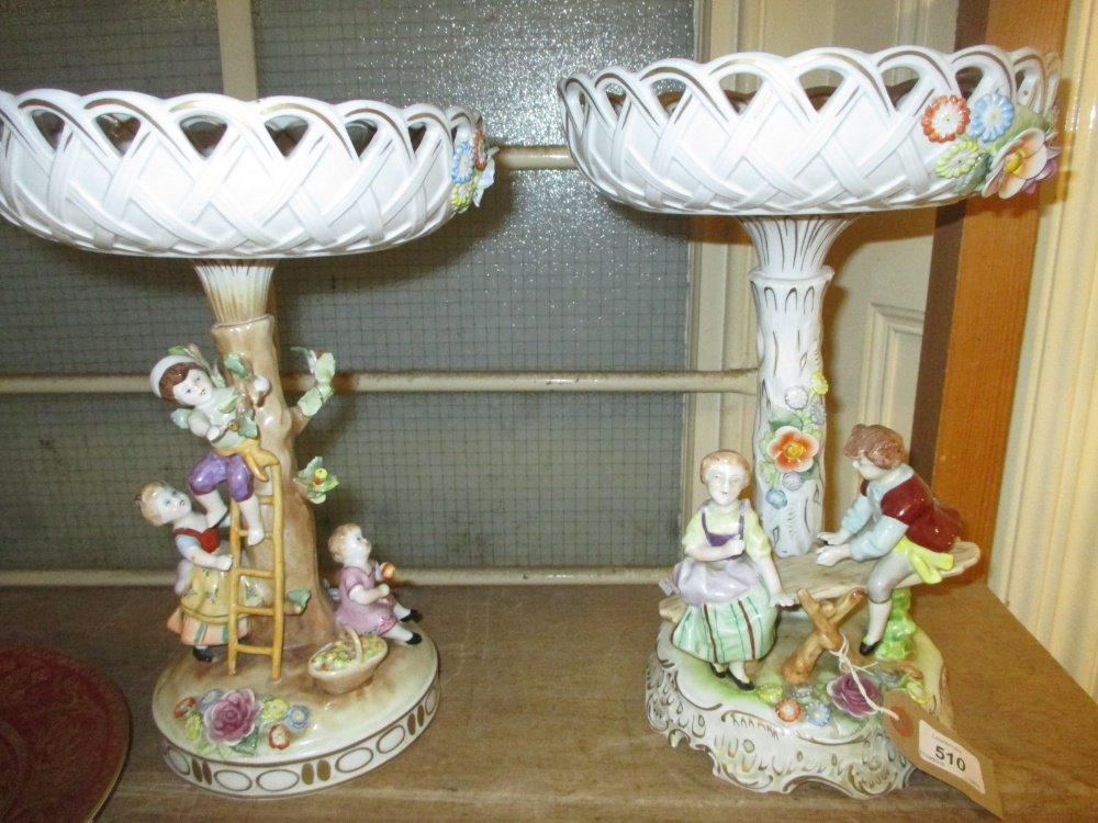 Near pair of mid 20th Century German porcelain comports: Near pair of mid 20th Century German porcelain comports with floral decorated and encrusted bowls above figural bases, 13ins high approximately