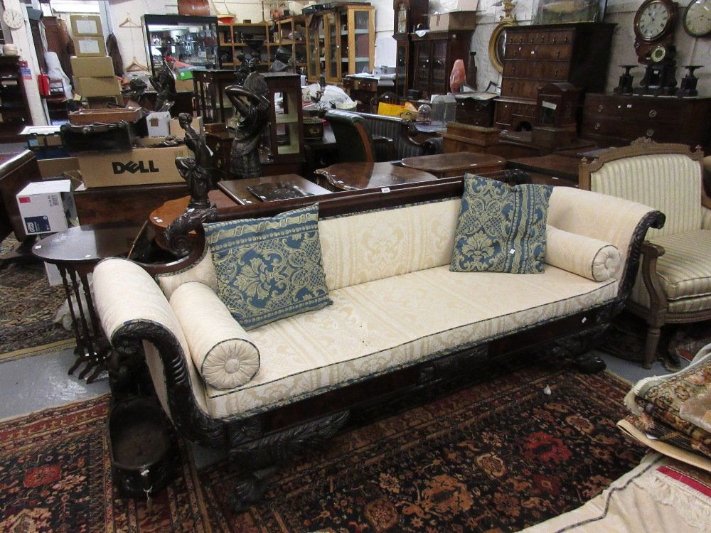 George IV carved mahogany sofa in the manner of Duncan: George IV carved mahogany sofa in the manner of Duncan Phyfe, the figured rail back and scroll ends carved with acanthus motifs and patera above a carved and moulded frieze raised on heavily carved pa