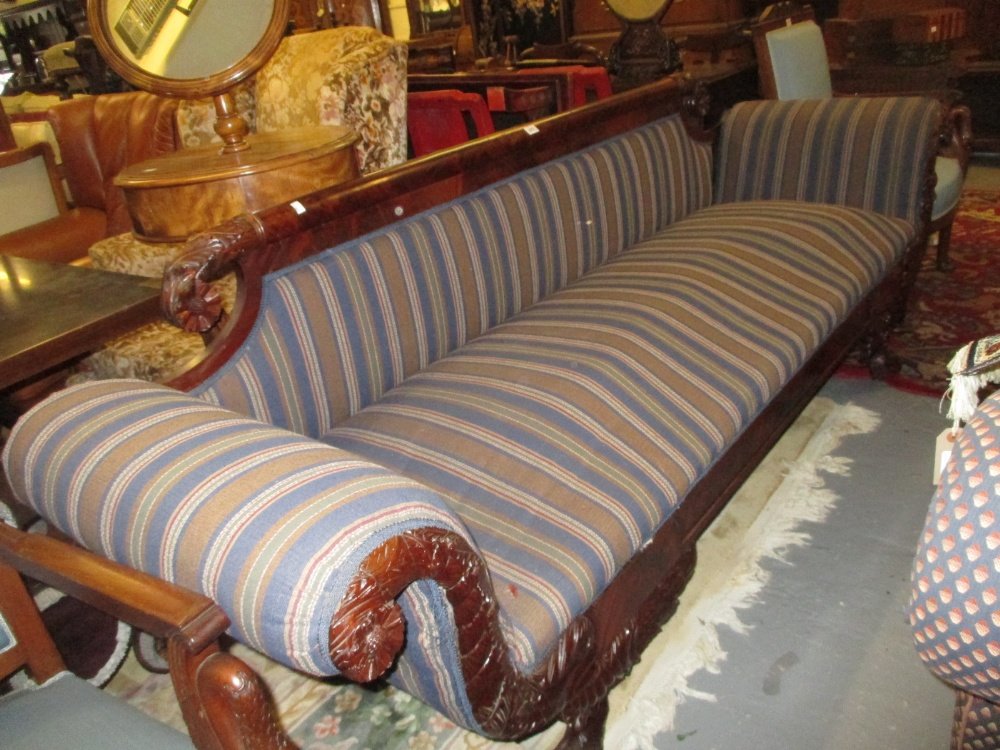 George IV mahogany sofa in the manner of Duncan Phyfe,: George IV mahogany sofa in the manner of Duncan Phyfe, the figured rail back and scroll ends with carved acanthus and floral decoration above a moulded frieze and carved cabriole paw supports, upholst