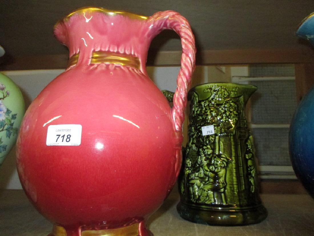 Large Sarreguemines pottery water jug decorated with a: Large Sarreguemines pottery water jug decorated with a turquoise glaze together with a similar pink glazed jug and another with relief decoration of figures outside a tavern
