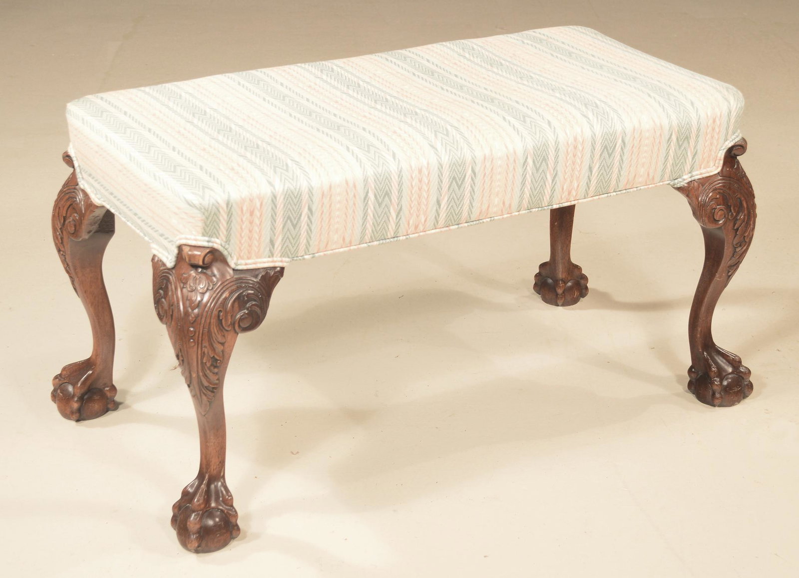 Mahogany foot stool: Chippendale style mahogany upholstered foot stool on cabriole legs with acanthus and bell flower carved knees and ball and claw feet, 33" wide, 17" deep, 18" high