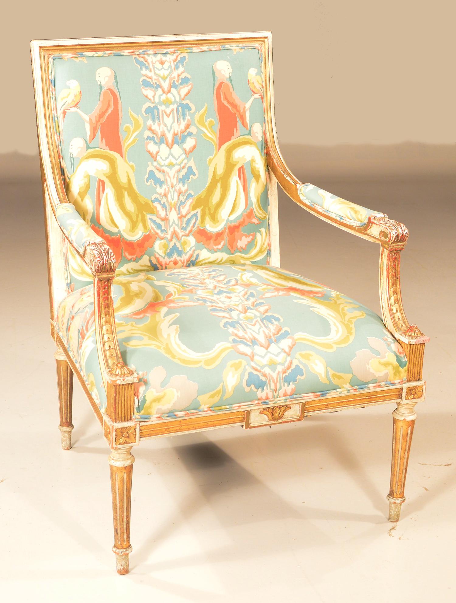Louis XVI style upholstered armchair: Louis XVI style gilt and white upholstered fauteuil with carved scroll arms, carved apron and on tapered fluted legs, c.1900, 26" wide, 24" deep, 37" high