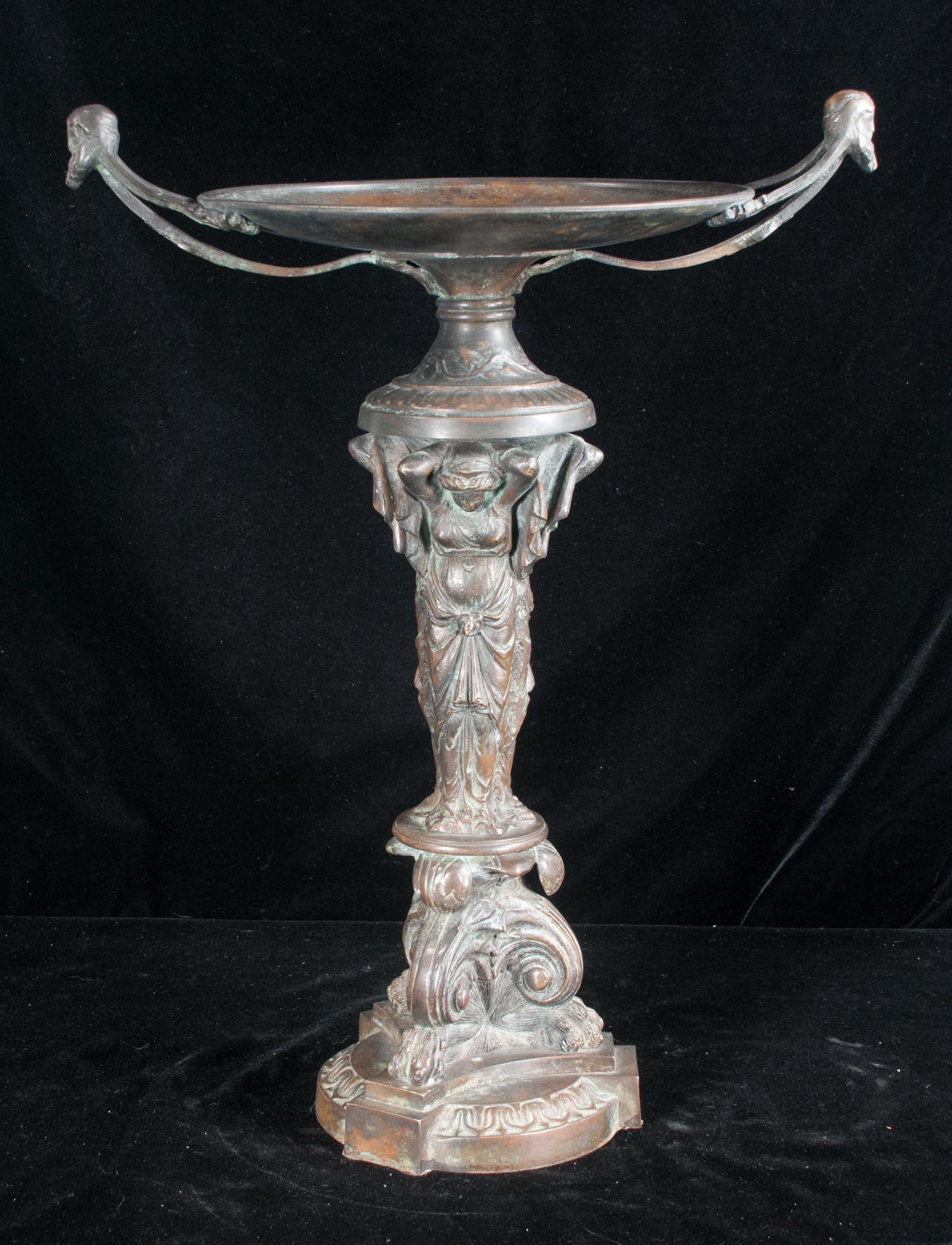 Bronze compote with double handles having mask: Bronze compote with double handles having mask decoration and supported by three ladies on a scroll base with paw feet, 16" wide, 21" high