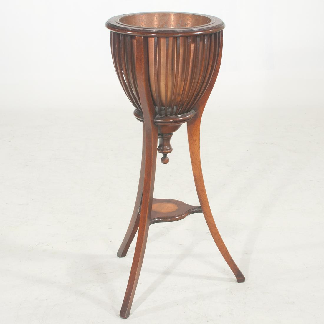 Sheraton style mahogany circular planter with copper: Sheraton style mahogany circular planter with copper liner, spindle sides on splay legs with a lower shelf having fan inlay, AF (one spindle is missing), 14" diameter, 33.5" high