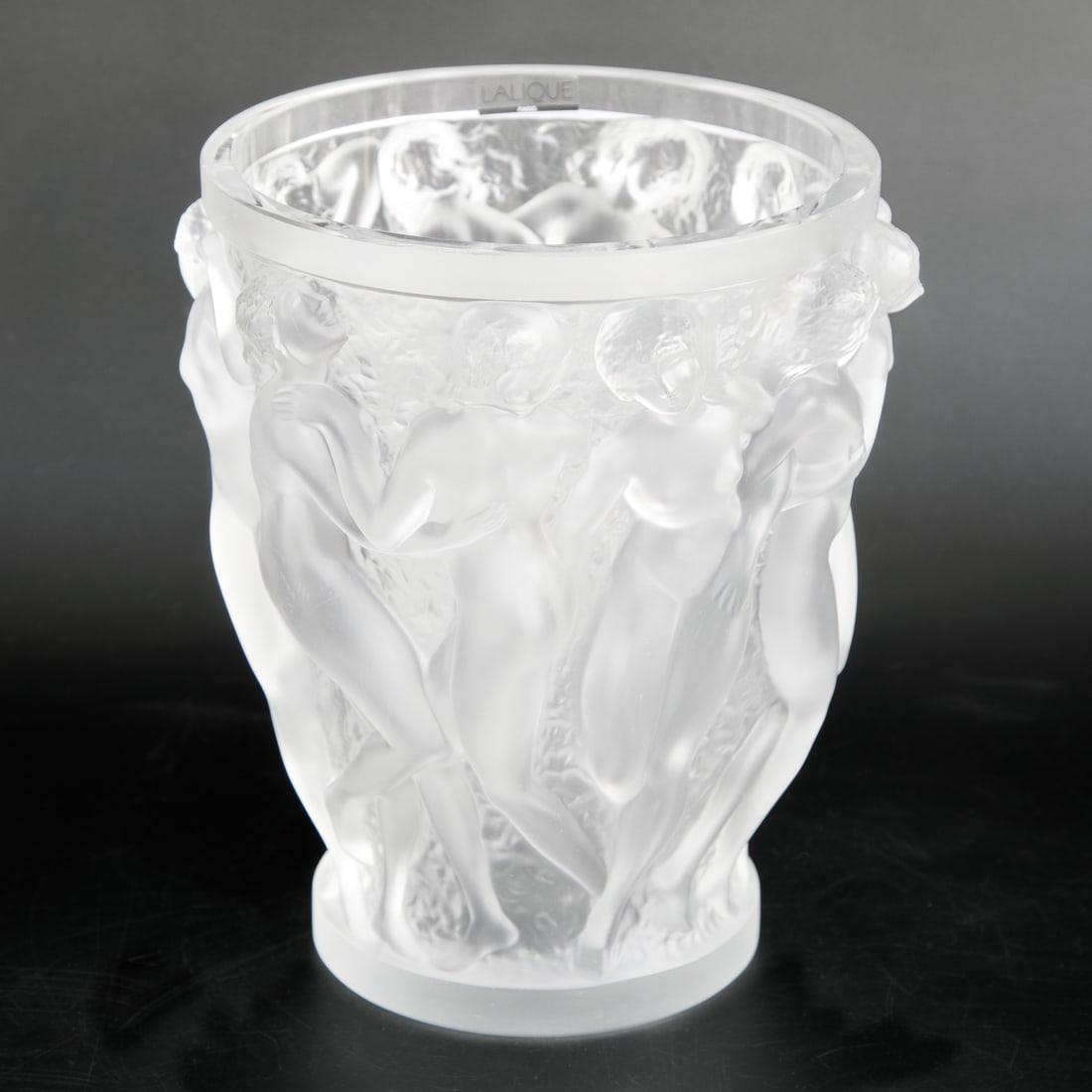 French Crystal Iconic Lalique Bacchante Nude Vase in Clear Color: French Crystal Iconic Lalique Bacchante Nude Vase in Clear Color, Featuring Nude Females Alongside Each Other, Original Sticker on Inside, Signed on Base. 8" Diameter, 9.5" High