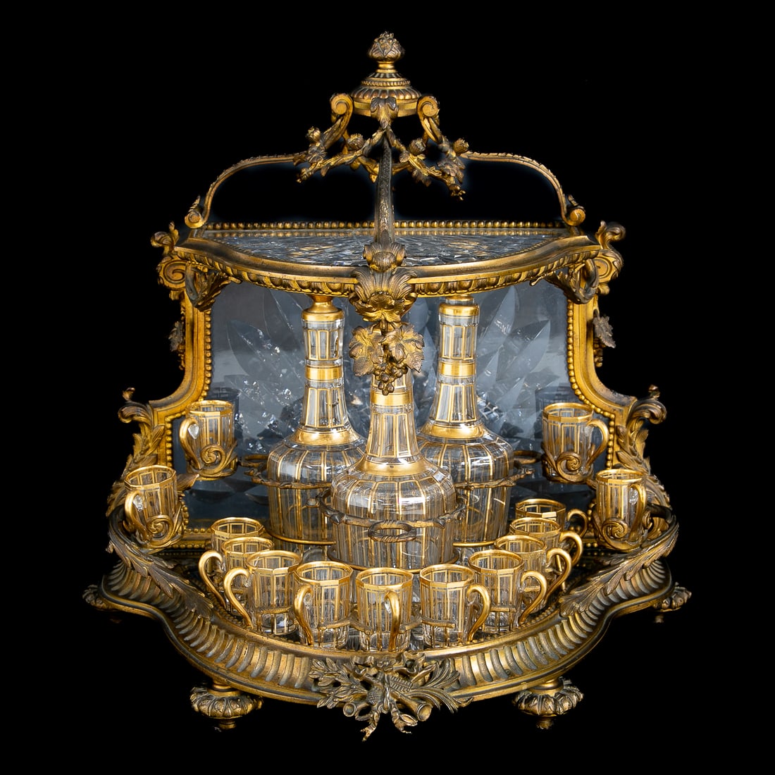 Gorgeous Late 19th C. French Gilt Bronze Cave a Liqueur/Tantalus Set: Gorgeous Late 19th C. French Gilt Bronze Cave a Liqueur/Tantalus Set, Having Demi Lune Shape, Open Crown Top Having Floral Finial, Three Branches, Floral Swags, Top Features Glass Top with Diagonal Fl