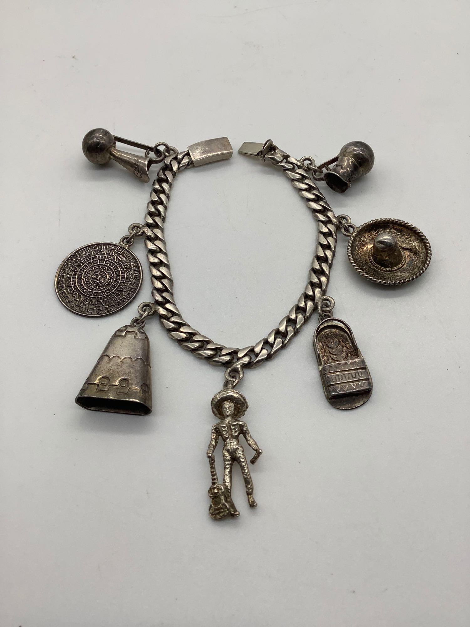 Mexican sterling silver charm bracelet w/ 7 sterling: Mexican sterling silver charm bracelet w/ 7 sterling charms. Ttw 39g, approx 7.5 inches.