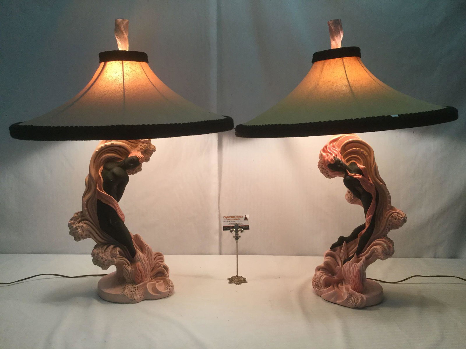 Mid-century pair Reglor lamps w/ pink/black male/female: Pair of mid-century Reglor lamps with pink and black, male and female sculpted bases riding a pink tide with pink and manila Moss shades, from California. Tested and working. Approx. 35x25x25 inches e
