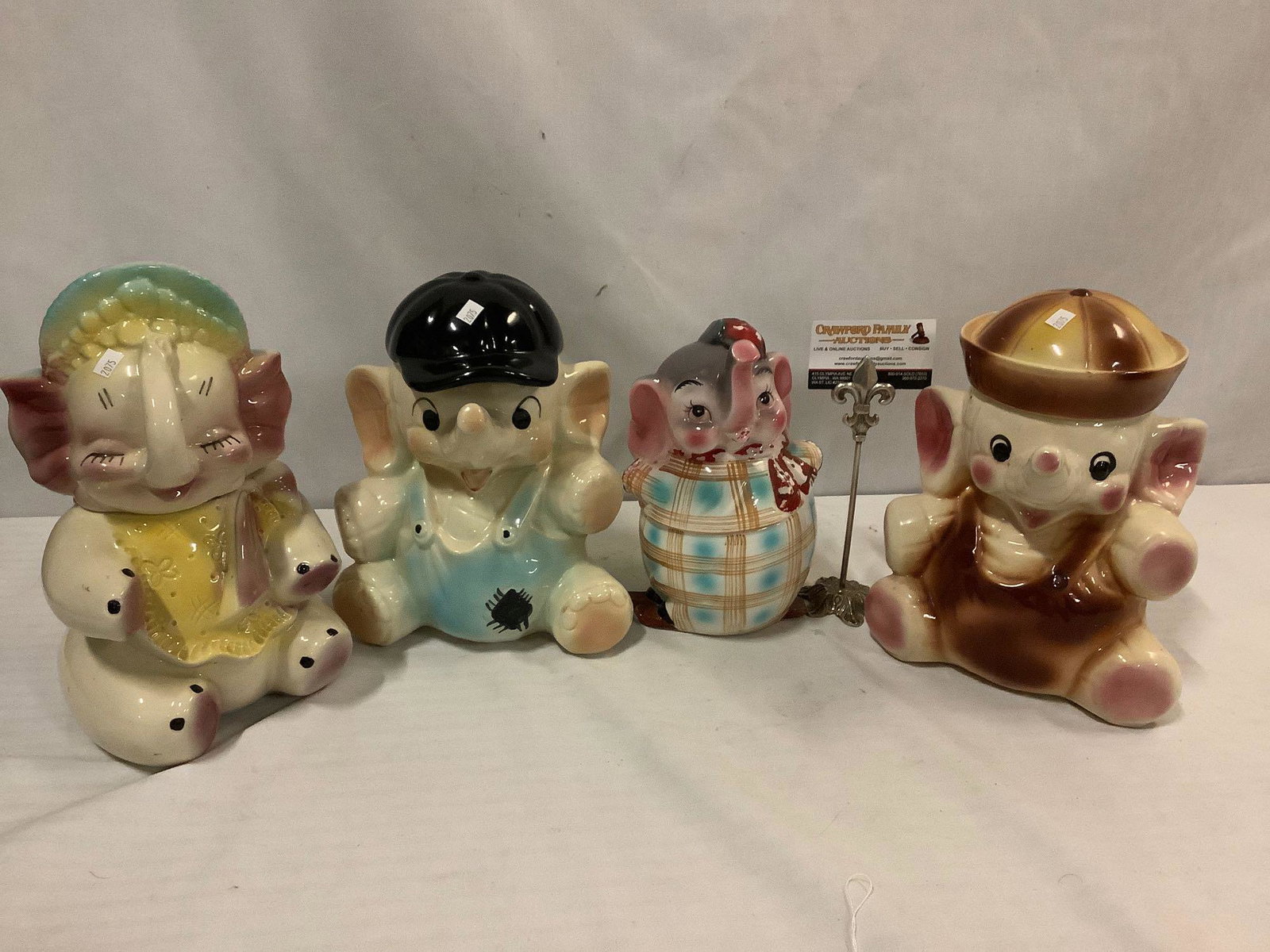 4 vintage elephant character cookie jars. One marked: 4 vintage elephant cookie jars. One marked USA. Largest approx 12x7x7 inches.