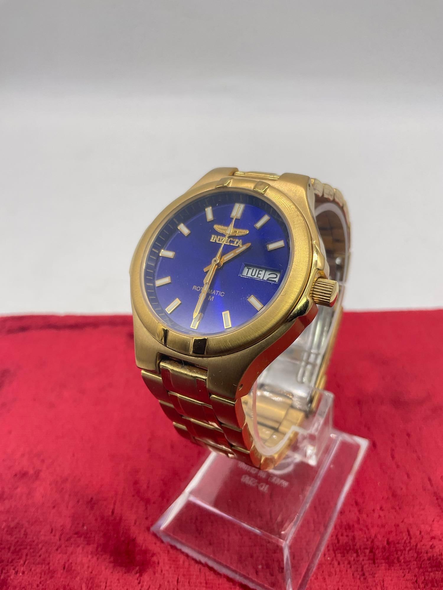 Invicta gold tone Rotomatic 50m quartz 20j wristwatch with skeleton back and blue face: All watches need batteries or servicing (if not a quartz movement) unless otherwise noted JC-2646