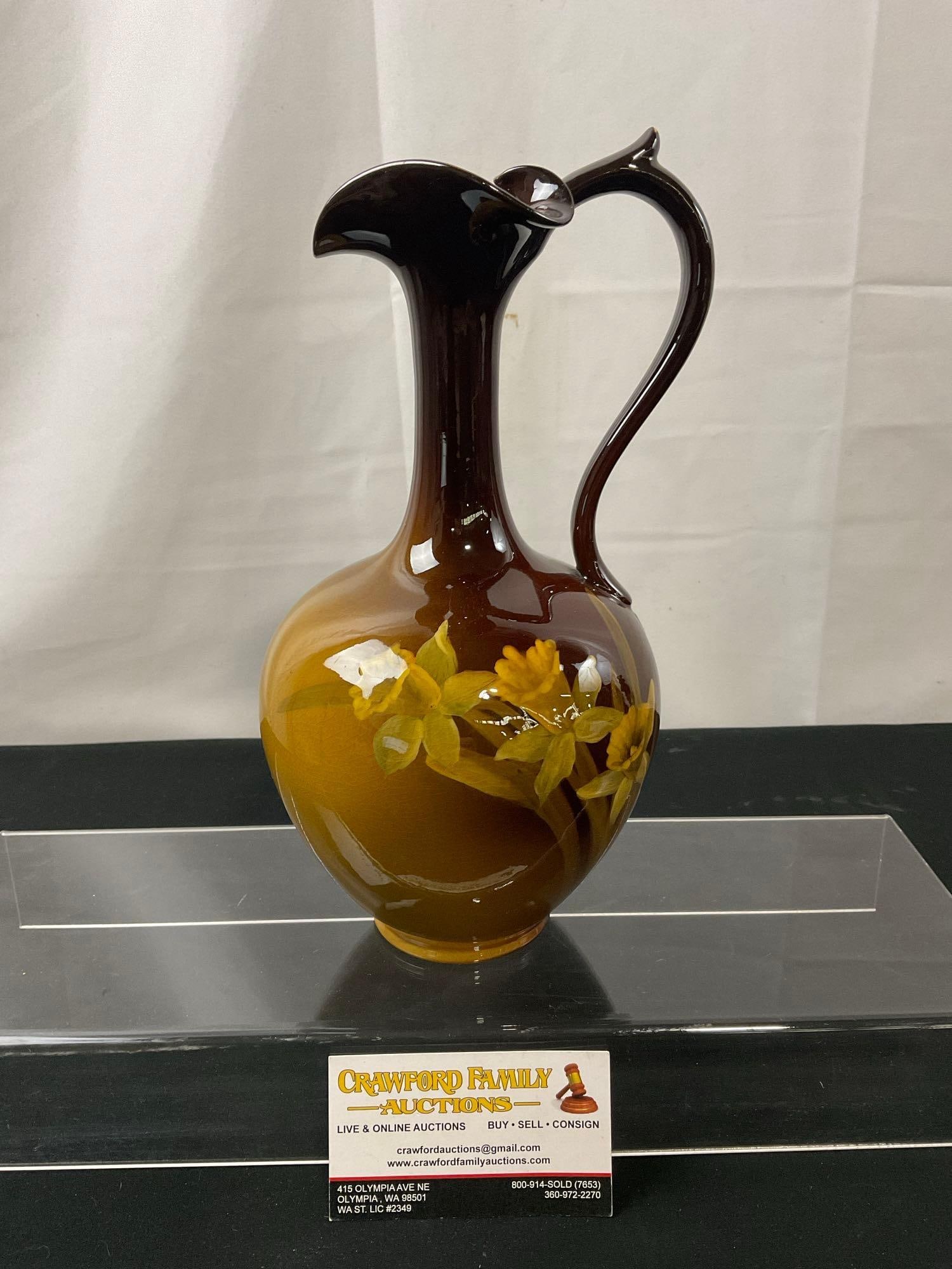 Vintage Rookwood Pottery Glazed Ewer, Brown to Yellow, Handpainted Daffodil Designs, 10 inch tall: Marked on the bottom, the Rookwood symbol, and 578 D. Appears to be in good shape, imperfection on the very top of it, a white section missing the glaze. Measures approx 10h x 5d inches. See pic