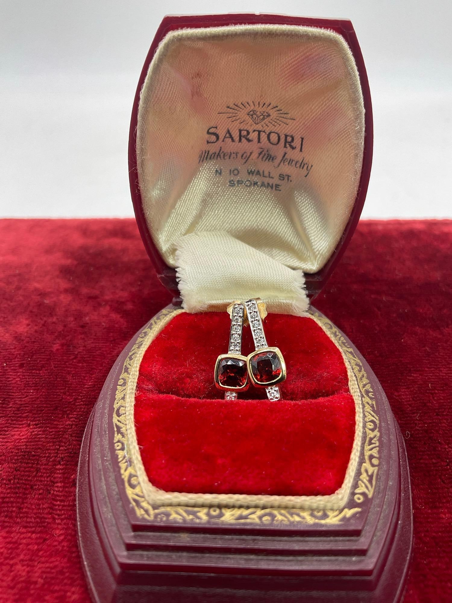Elegant Set of 14K gold earrings , featuring 5mm cushion cut garnets & 6 round Cut VS-2 diamonds: SC- 2770 Each earring features 5mm cushion cut garnets & 6 round Cut VS-2 diamonds I or better in color with the total cts weight at 0.07 or better . In original presentation box a