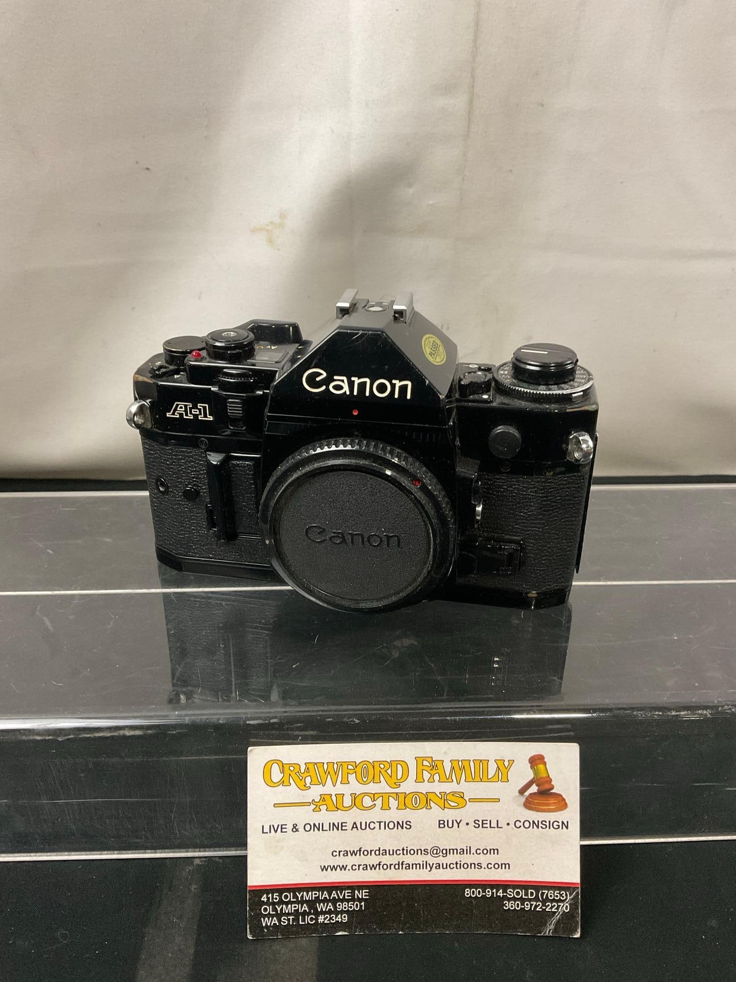Vintage Canon A-1 SLR 35mm Film Camera, black in color: No. 1008420. Appears to be in good shape, seems to operate smoothly. See pics. E-414