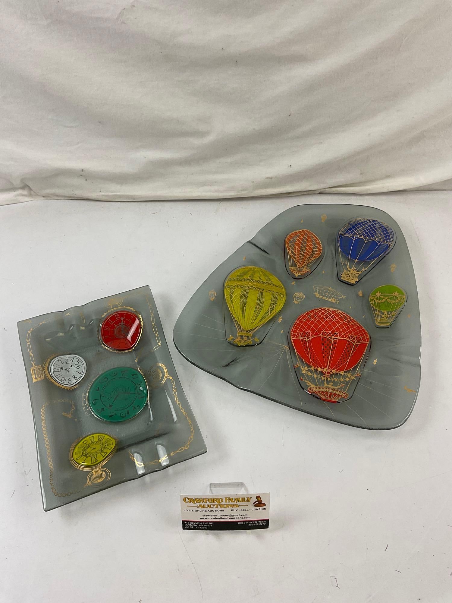 2 x Mid Century Higgins Gray Glass Ashtrays w/ Colorful Designs. Pocket-watches. Hot Air Balloons: 2 pcs Very cool Vintage Higgins Gray Glass Ashtrays w/ Colorful Designs. Pocket-watches & Hot Air Balloons. Measures 12" x 14.5" x 2" Condition is fair to good. DM-414