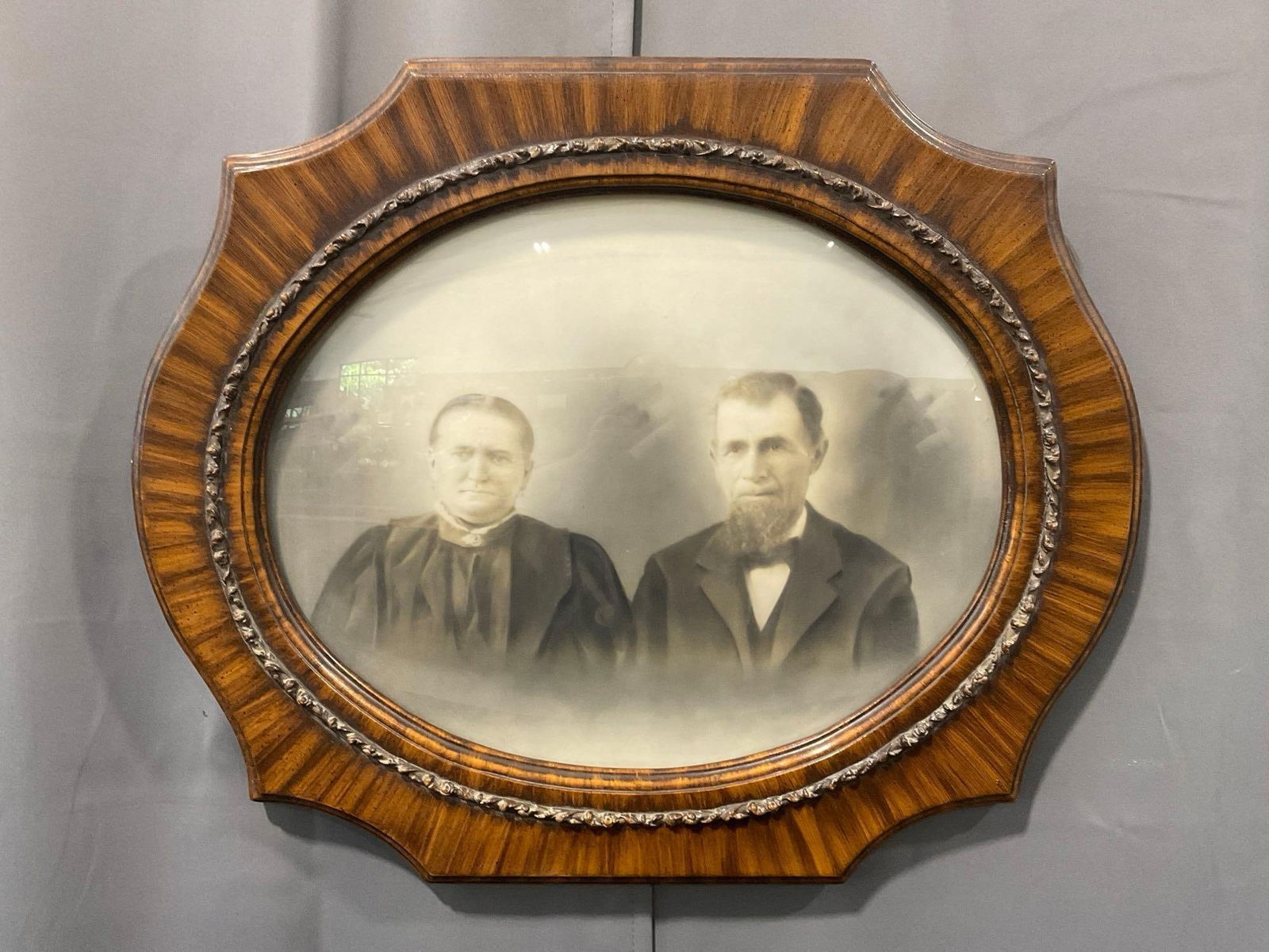 Antique Bubble Domed Portrait Old Timey Couple, w/ Wood Grain Painted Frame, 22.5h x 27w inches: Previously sold for about 89 dollars. Appears to be in good shape. The outside dimensions measure approx 22.5h x 27w x 3d inches. See pics. E-4230