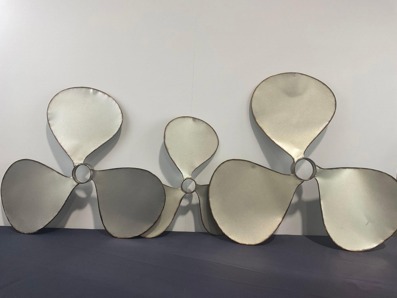 Set of 3 Propeller Wall Hangings, Small, Medium & Large, largest measures approx 24 inches across: All are marked w/ ZIM-47253, then S, M & L for the size. Appears to be in good shape. The three pieces measure approx 3.5h x 24w x 24d inches. See pics. E-4130