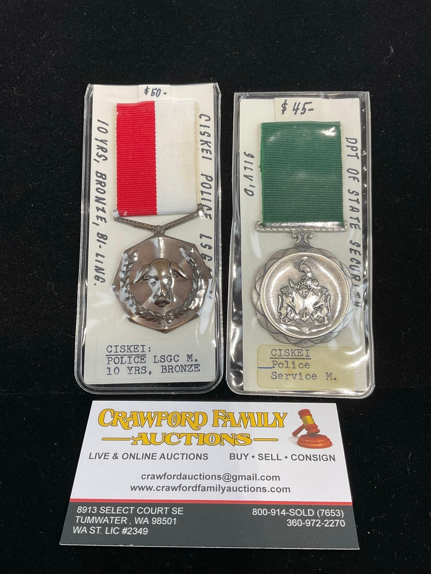 Pair of South African Ciskei Medals, Police LSGC 10 Years, Bronze & Dpt of State Security Service: Part of what is now South Africa. All from a single collection, these are briefly described on the tag and were kept in a display. They measure approx 6h x 3w x 2d inches. See pics. E-5300