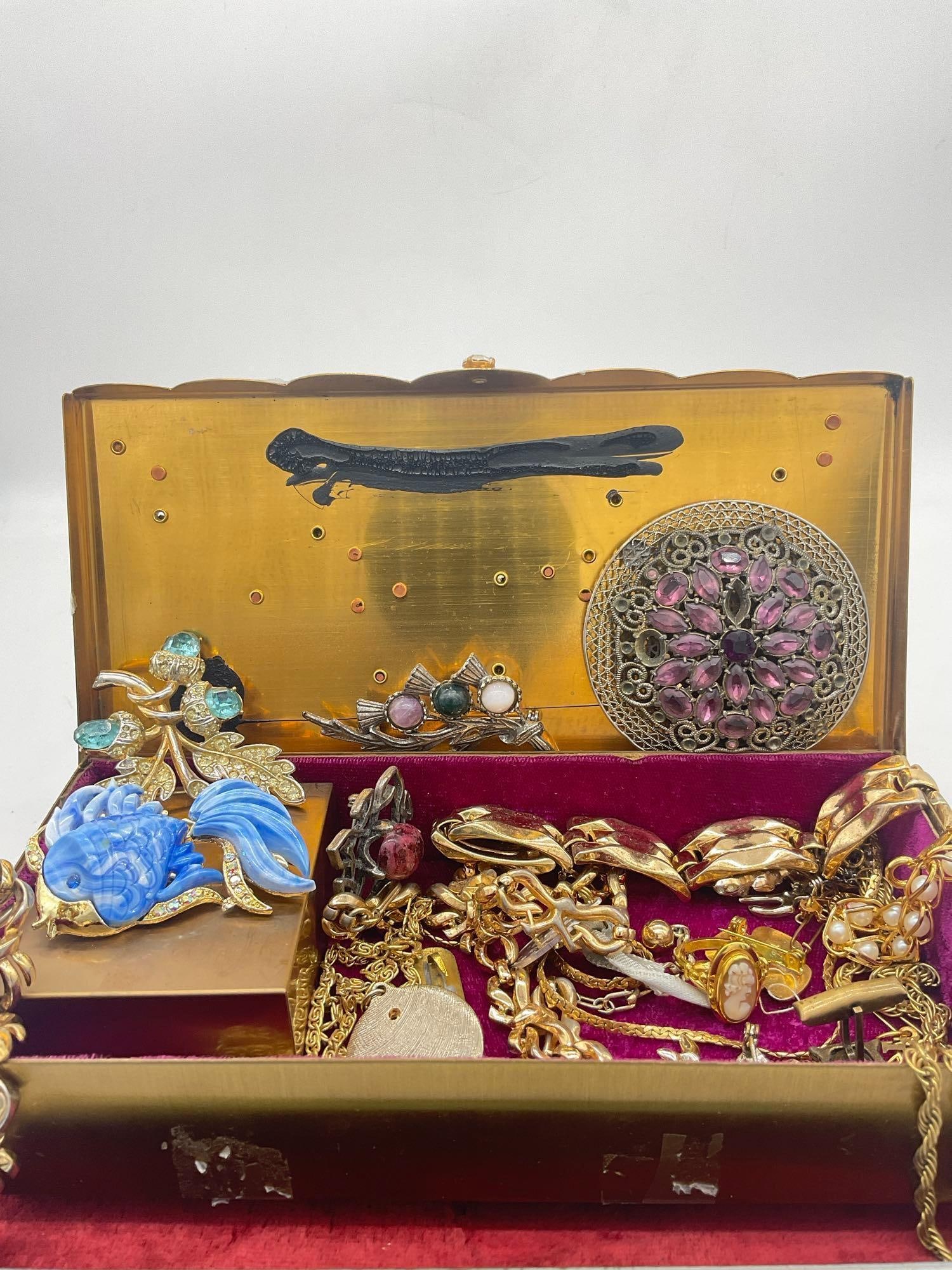 Vintage Gold toned music Music Jewelry Box w/ Rhinestones filled with vintage jewelry see pics: c-4660 Rhinestone brooches, Trifari Bracelet & Necklace, Napier Faux pearl and gold toned bracelet, plus assorted jewelry see pics Jewelry Music box works, has a loose mirror &