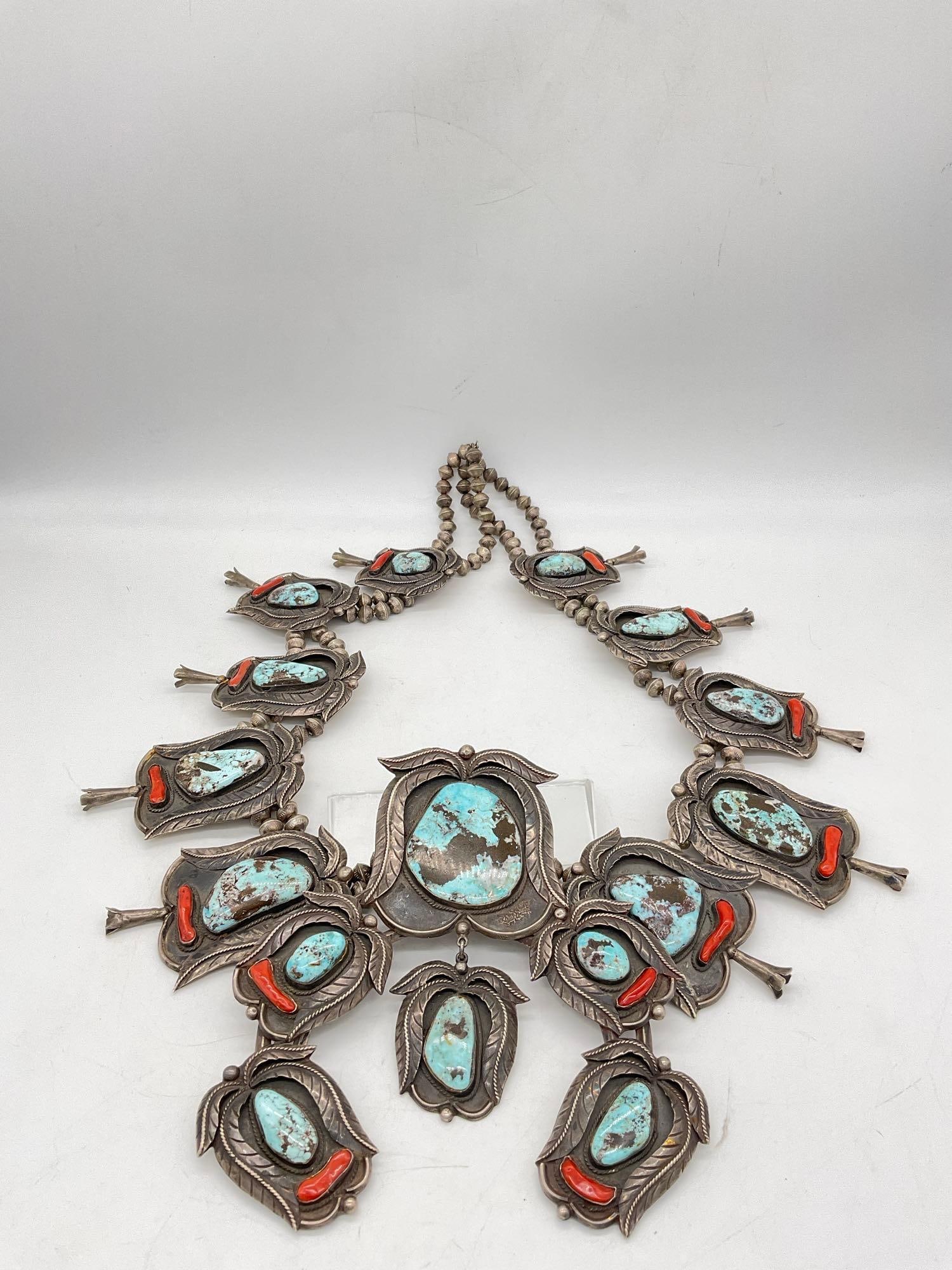 Navajo Native American ceremonial squash blossom necklace studded w/ turquoise & coral: Pendant is Approx 6 inches by 7 inches, and is approx 34" in length, with graduating size blossoms. This is an incredible One of a Kind Native American silversmithing masterpiece. The accompanying bra