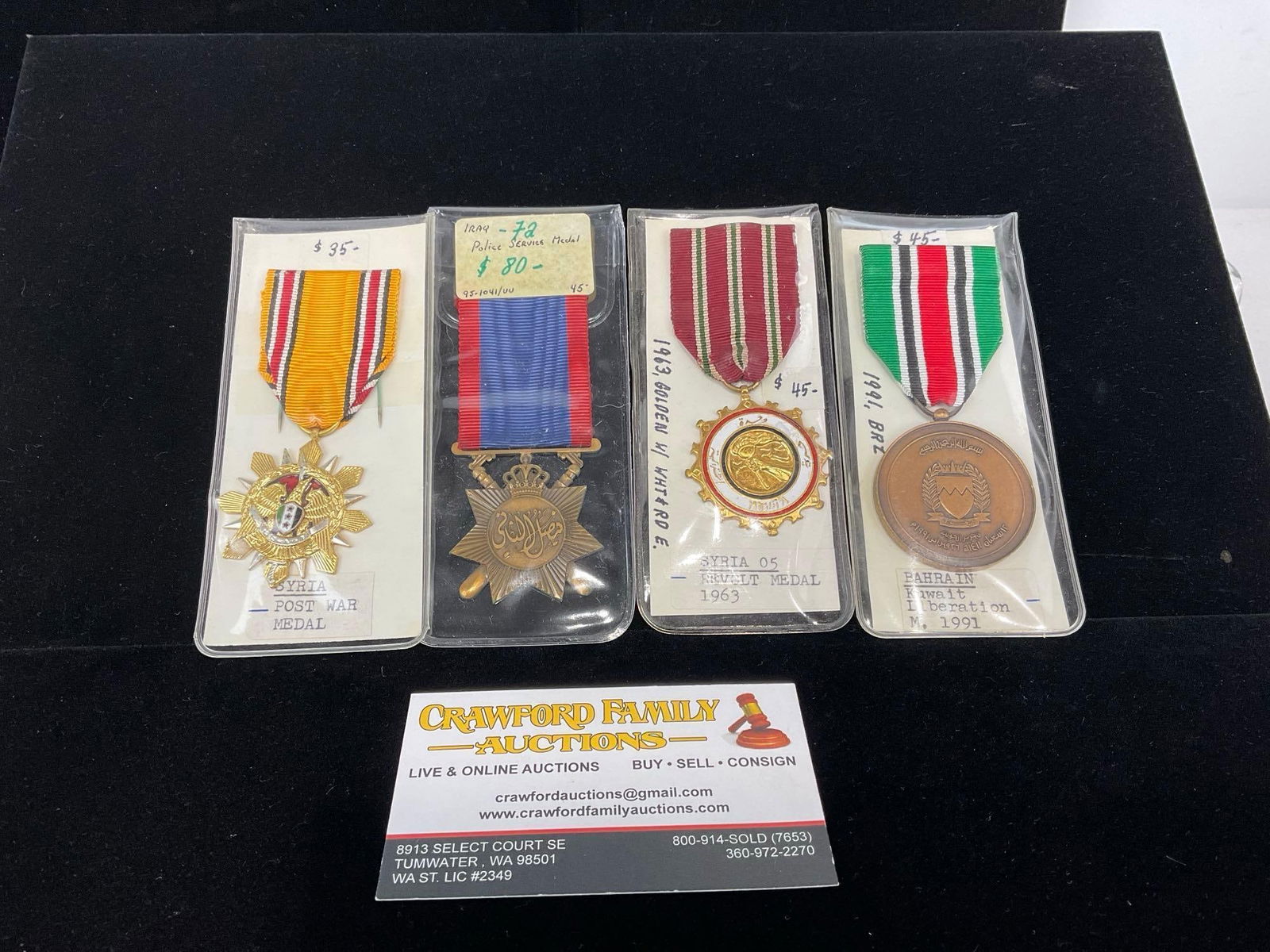 2 Syrian Medals Post War & Revolt 1963, Bahrain Kuwait Lib. 1991 & Iraqi Police Service Medal: All from a single collection, these are briefly described on the tag and were kept in a display. They measure approx 6h x 3w x 2d inches. See pics. E-5300 
