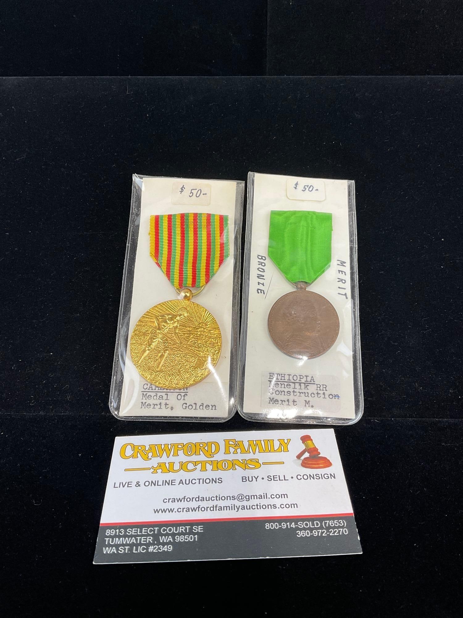 Cameroon Medal of Merit, Gold Tone Metal, & Ethiopia Menelik Railroad Construction Merit Medal: All from a single collection, these are briefly described on the tag and were kept in a display. They measure approx 6h x 3w x 2d inches. See pics. E-5300