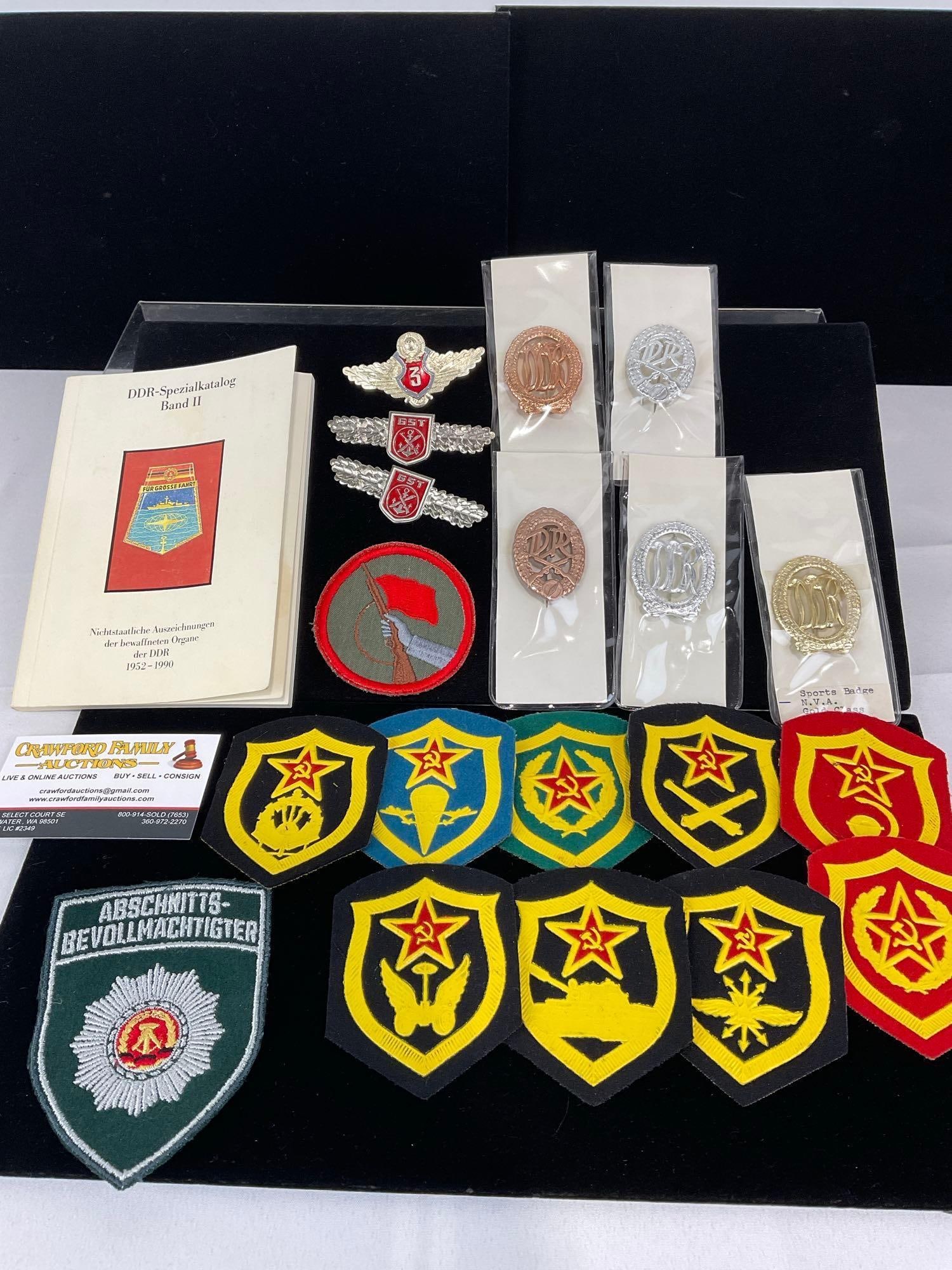 GDR East German Pieces, GST Pins, GDR & 9 USSR Patches, 5x NVA Sports Badges: All from a single collection, these are briefly described on the tag and were kept in a display. They measure approx 6h x 3w x 2d inches. See pics. E-5300 