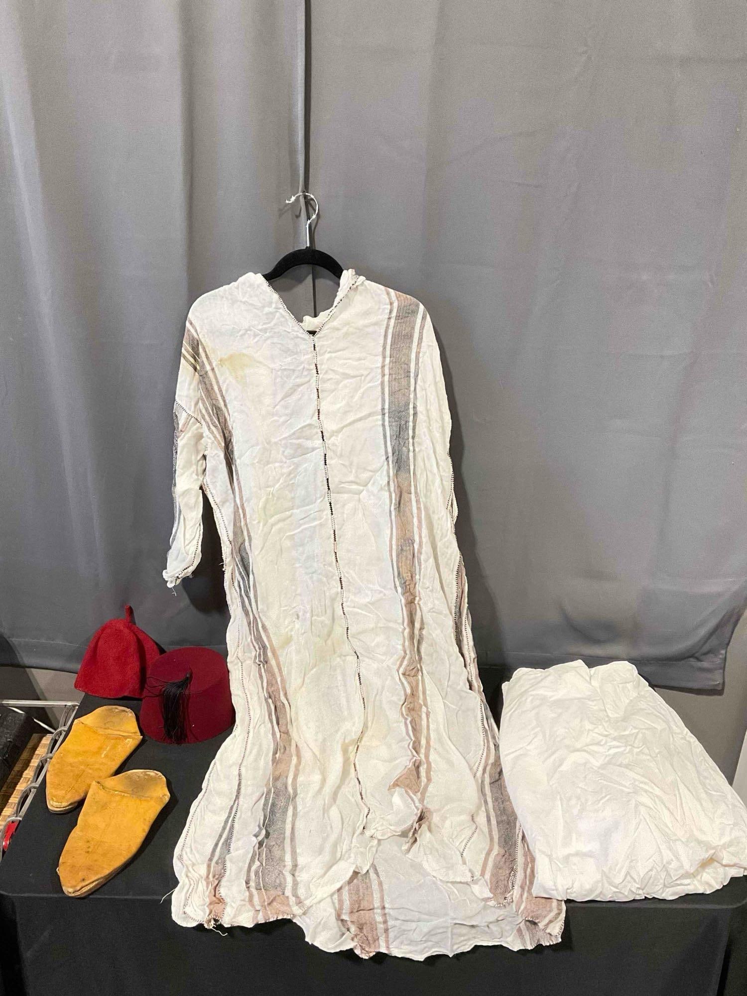 5 pcs Vintage Moroccan Clothing, incl. 2x Red Hats, 1x Pair Leather Shoes, 2x Long Tops. See pics.: 5 pcs Vintage Moroccan Clothing, incl. 2x Red Hats, 1x Pair Leather Shoes, 2x Long Tops. Pieces have wear indicative of age, stained, condition is otherwise good. Tops look like a combination of linen