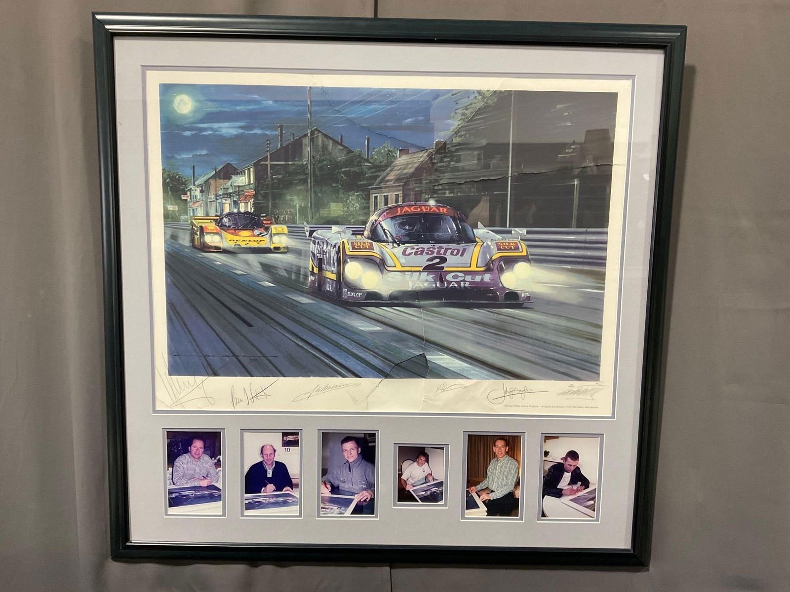 Framed Signed Artists Proof titled Duel on Mulsanne by Nicholas Watts, Signed by 6 Drivers w/COA: Has some tears across the piece, has the glass panel loose in the frame. The piece is signed by the artists, and by the drivers along the bottom with the pictures of them. The piece measures approx