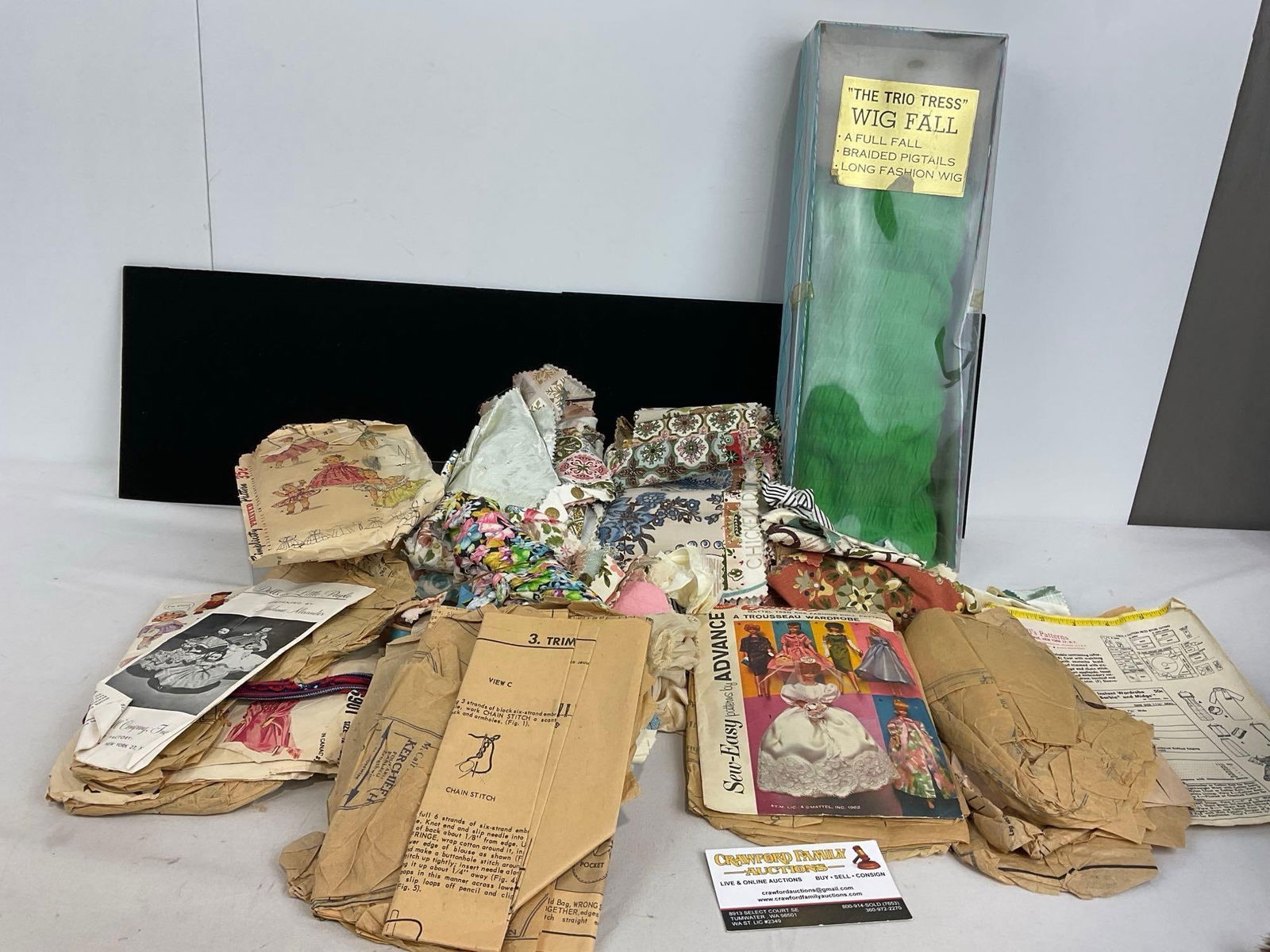 Assortment of Fabrics, Doll Clothing Instructions, The Trio Tress Wig Fall & more: Appears to be in fair to good shape. The pieces measures approx 7h x 17w x 7d inches. See pics. E-5180 