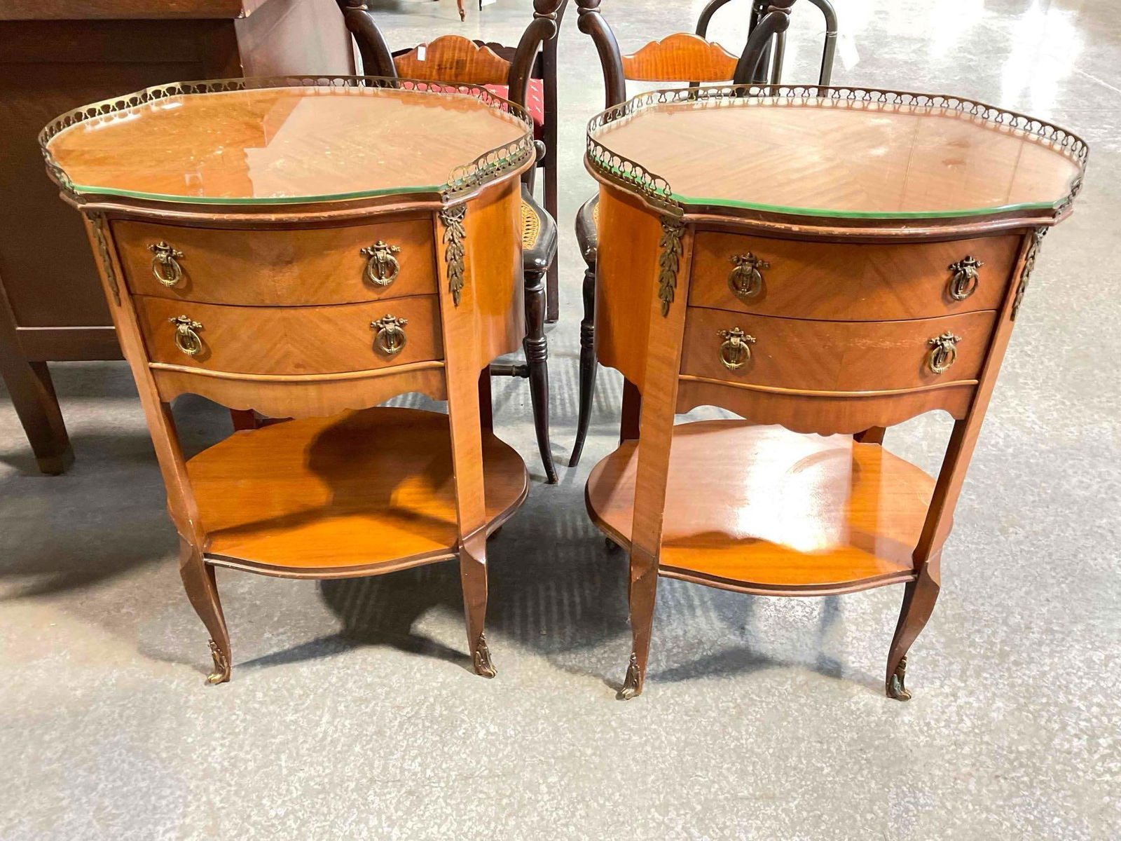 Pair of Vintage French Style Maple 2-Tier Bedside Tables w/ Glass Tops & Brass Accents.: Pair of Vintage French Style Maple 2-Tier Bedside Tables w/ Glass Tops & Brass Accents. Handsome grain and nice details. Some wear indicative of age, one has a loose foot cap and 2x oxidized foot