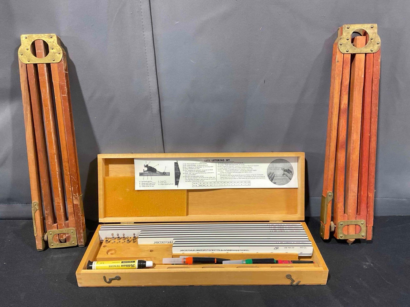 3 pcs Vintage Tool Assortment, incl. Lutz/K+E Leroy Letter Sets & 2 Wooden Tripods. See pics.: 3 pcs Vintage Tool Assortment, incl. Lutz/K+E Leroy Letter Sets & 2 Wooden Tripods. Minor wear indicative of age, condition is otherwise very good. Measures 5" x 18" x 2" DM-5570 