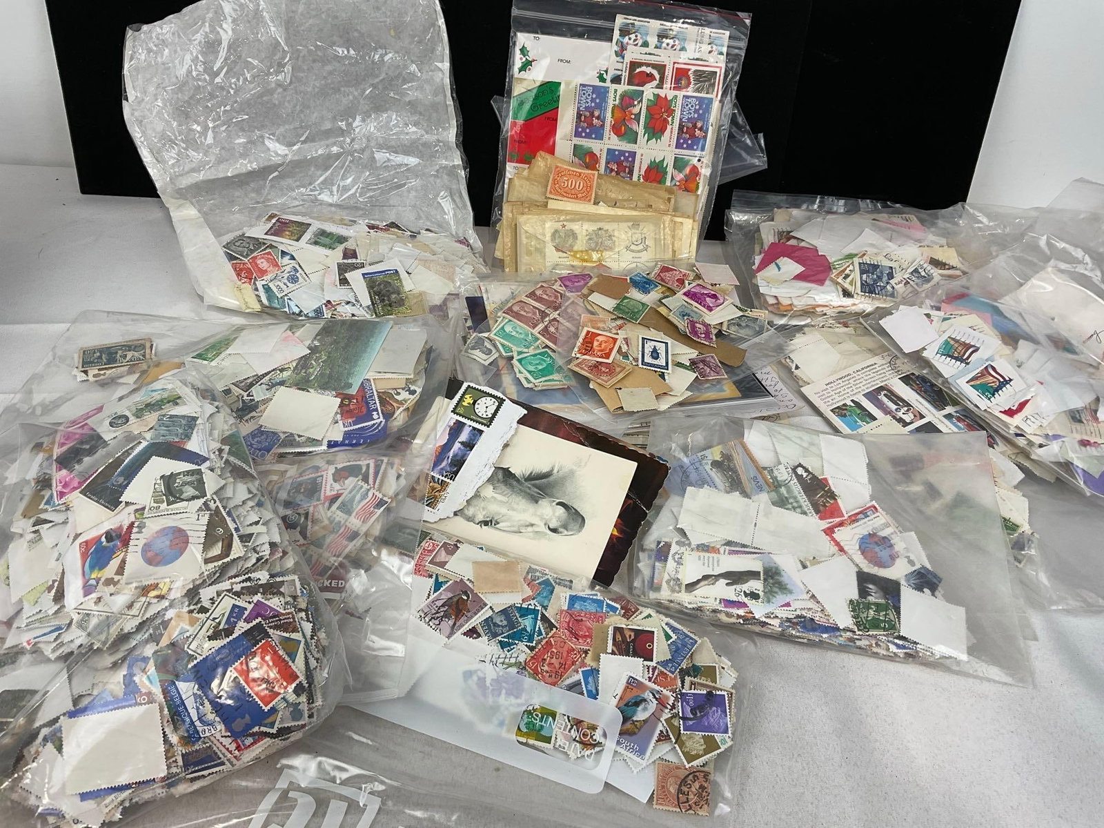Large Assortment of Stamps, in various bags, envelope corners, postcards & more: Appears to be in good shape. The piece measures approx 9h x 14w x 10d inches. See pics. E-5670 
