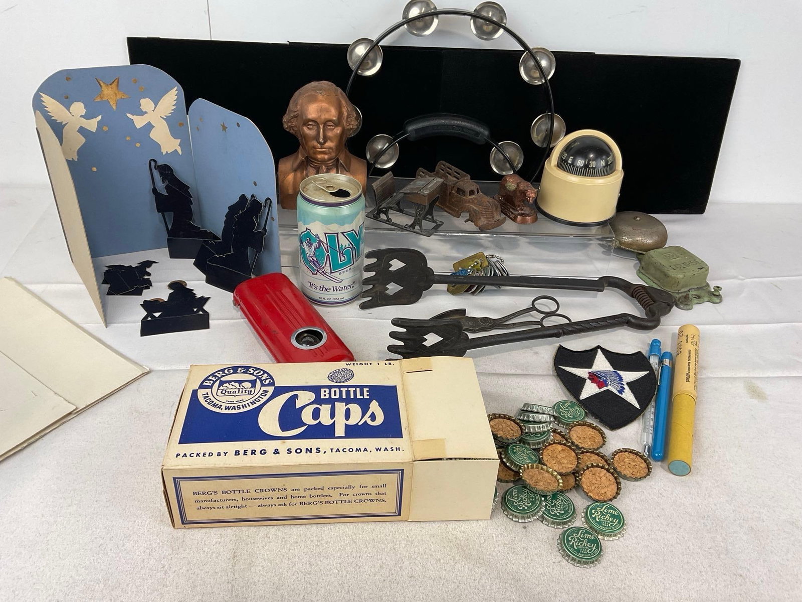 Tongs, Coin Bank, Paper Nativity, Compass, Vintage Bottle Caps, 1940s Work Light, Alarm Bell & more: Appears to be in good shape. The piece measures approx 3h x 20w x 16d inches. See pics. E-5360