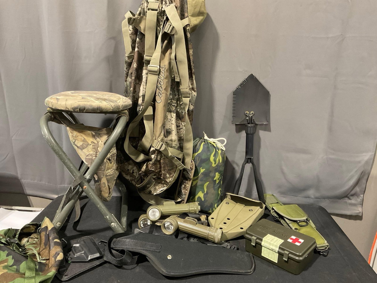 Trenching Tool, Cabelas Duffle Bag, Sheaths, 4 Clip Flashlights, First Aid Kits, Camp Stool & more: Appears to be in good shape. The piece measures approx 30h x 18w x 16d inches. See pics. E-5600