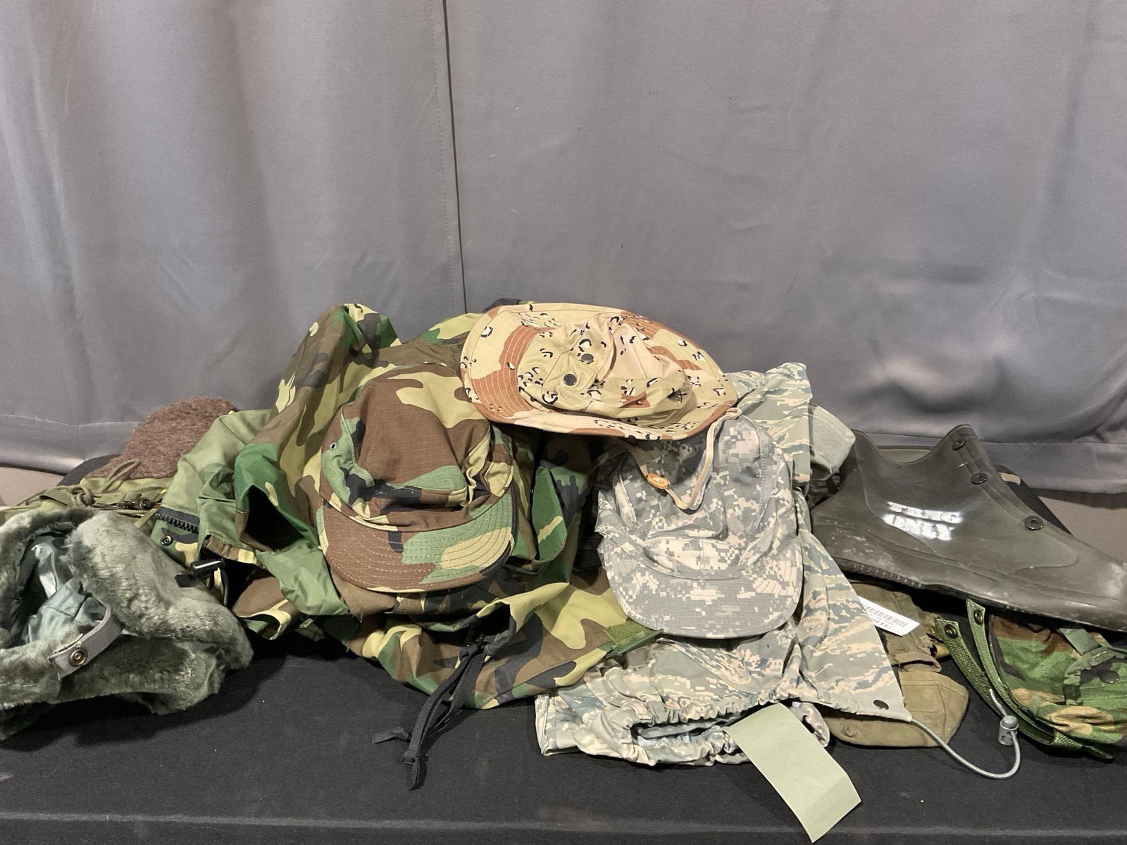 Assortment of Camos, Rain Gear, 3 Hats, , Size 10 Boots, Trousers & more: Appears to be in good shape. The piece measures approx 17h x 25w x 16d inches. See pics. E-5600