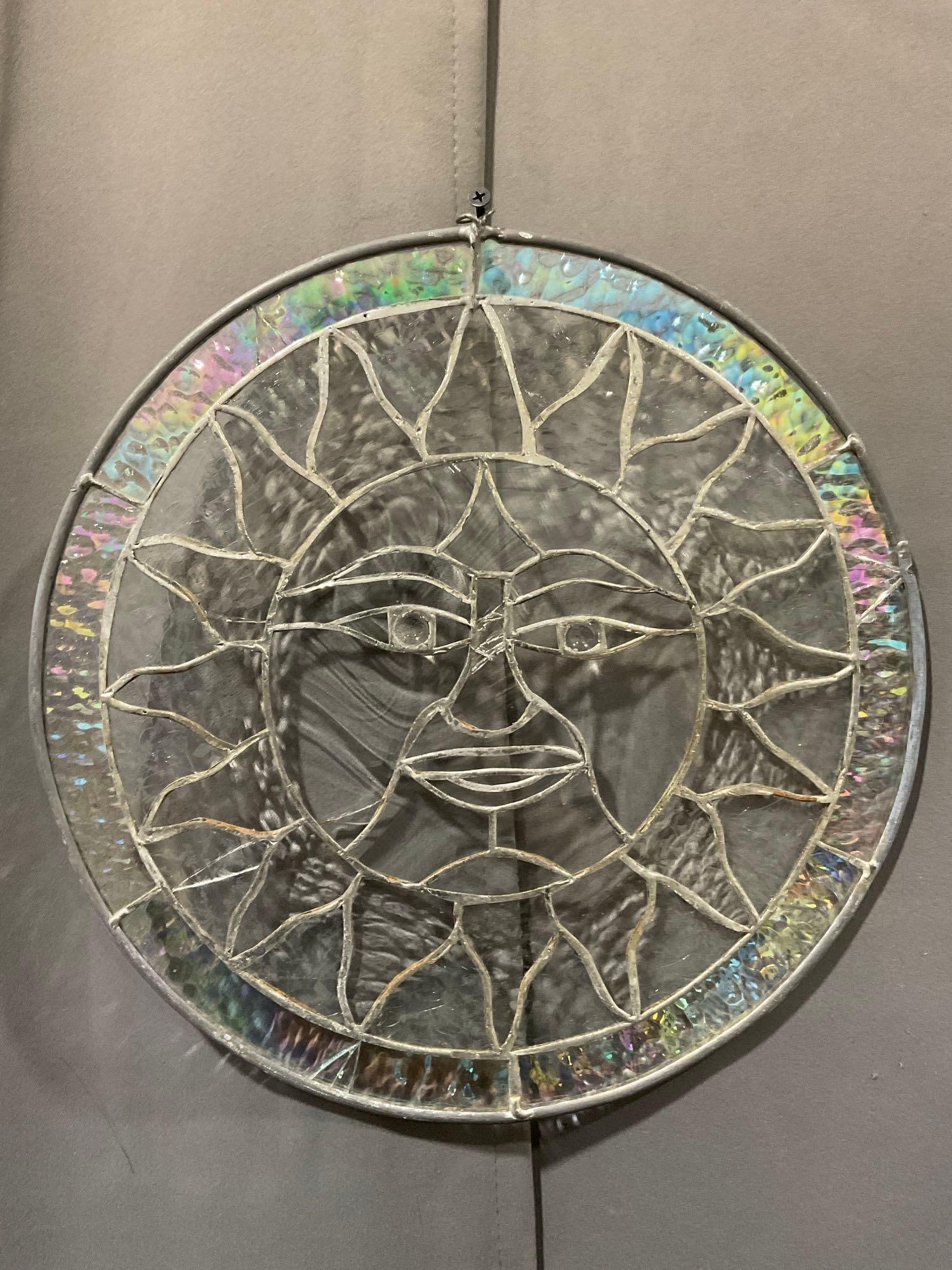 Circular Stained Glass Sun Image, Iridescent rim, 14 inches in diameter, some cracks: Appears to be in fair to good shape, some cracks in a few of the panels. The piece measures approx 14h x 14w x 3d inches. See pics. E-5860